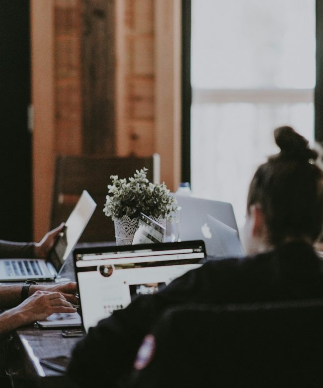 selective focus photography of people sits in front of table inside room